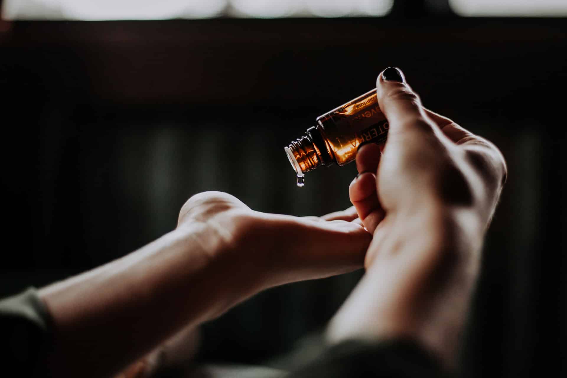 Zwei Hände halten eine kleine Flasche Öl für Massagen in Bad Krozingen