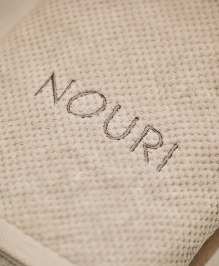 Das Logo vom Hotel Nouri auf einem Badetuch für Massagen in Bad Krozingen