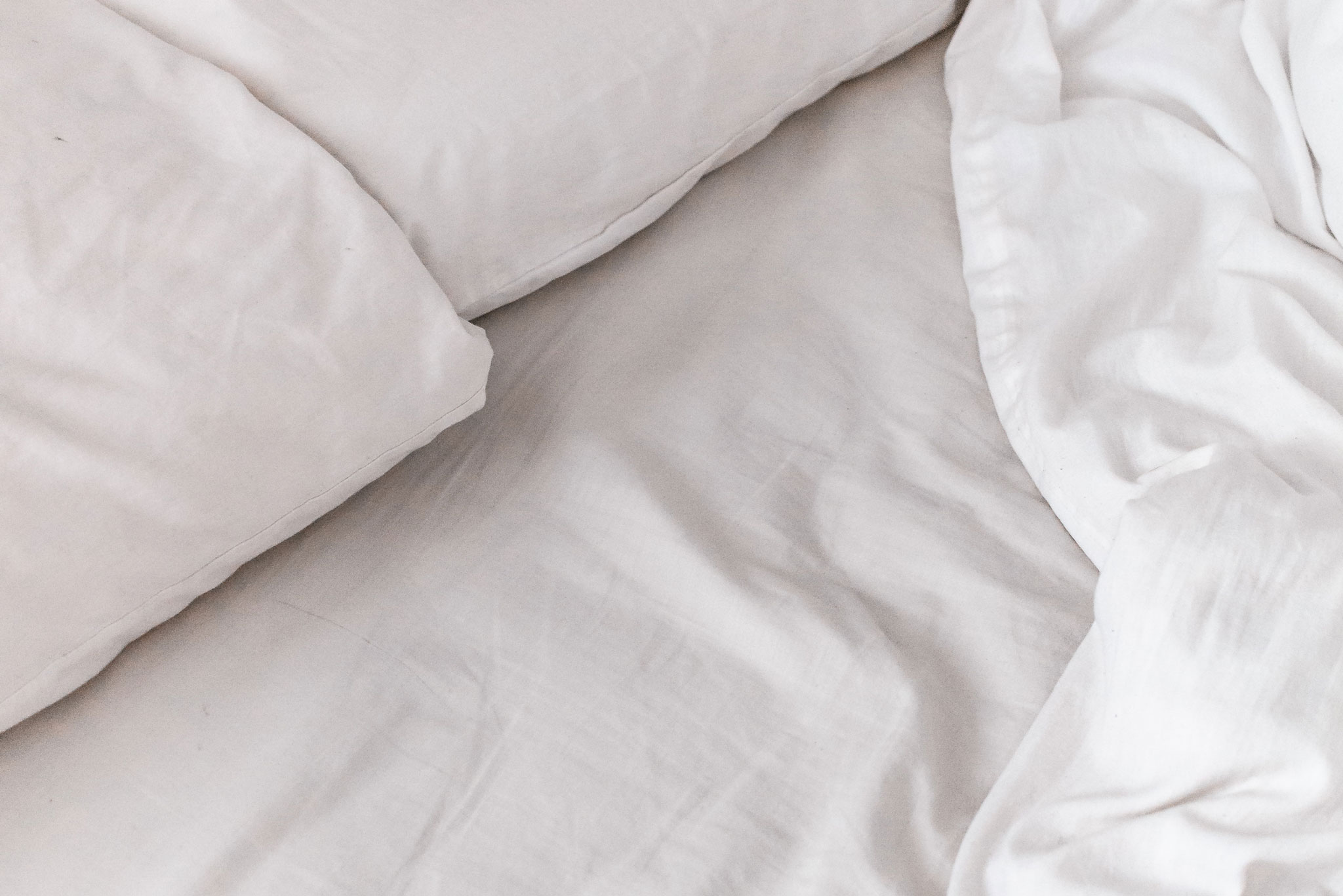 Nahaufnahme der weißen Bettwäsche auf dem Bett